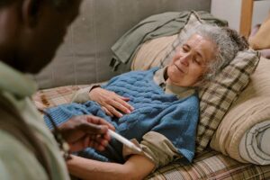 Mujer adulta mayor descansando acostada en una cama