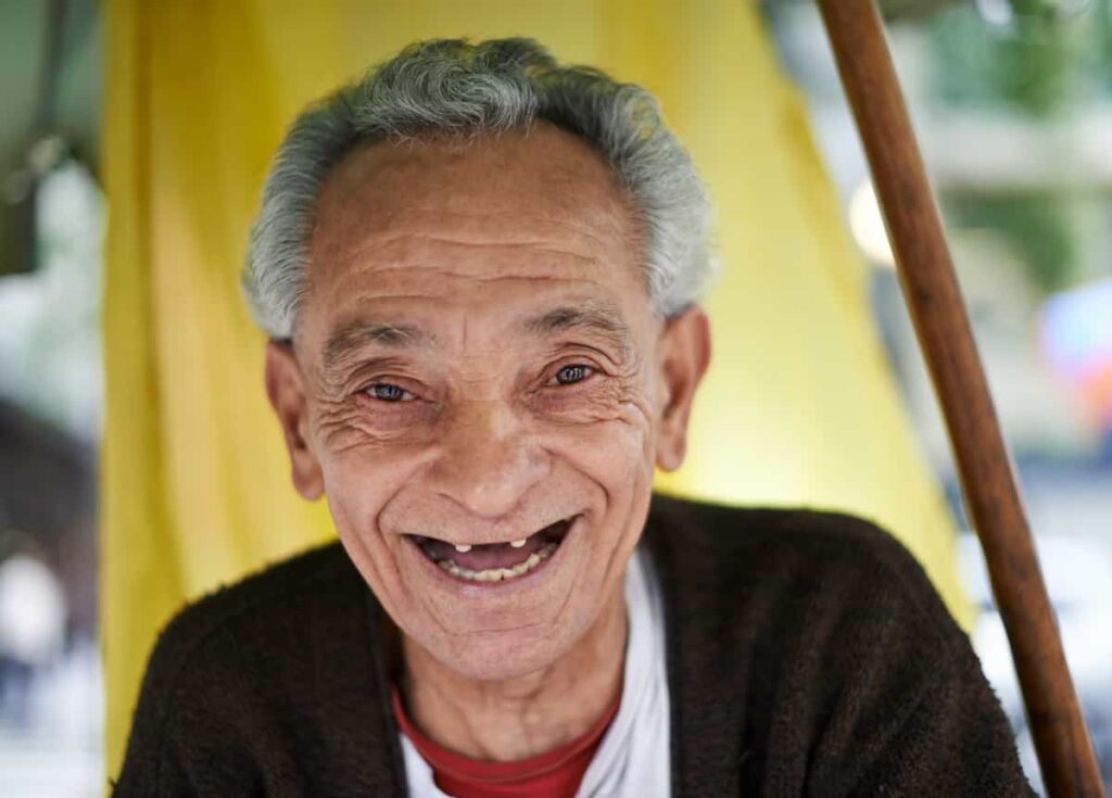 Adulto mayor sonriendo alegremente a la cámara