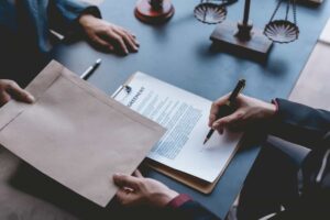 Profesionales firmando un acuerdo legal sobre una mesa