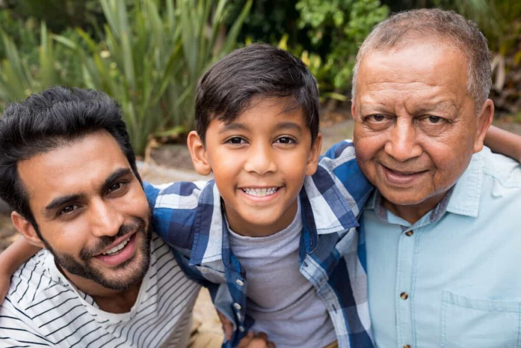 Niño sonriendo junto a su abuelo en un retrato familiar