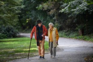 Pareja de adultos mayores caminando junta por un parque