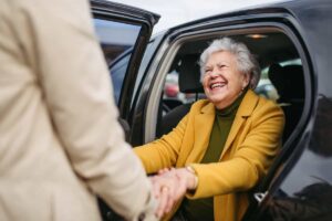 Mujer adulta mayor sonriendo mientras está sentada en un automóvil