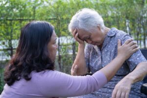 Mujer joven consolando a una adulta mayor al aire libre
