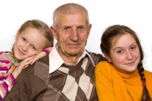 Abuelo acompañado por sus nietas en un retrato familiar