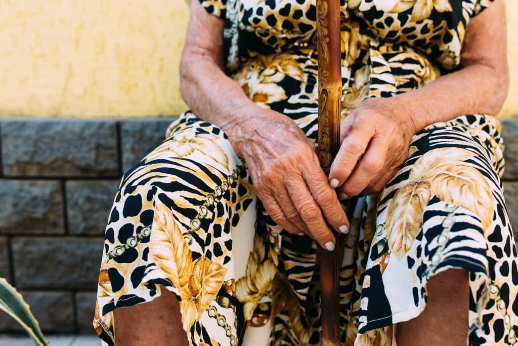 Mujer adulta mayor sentada con las manos sobre el regazo