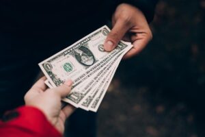 Persona entregando dinero en efectivo a otra persona