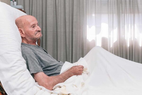 13145-senior-man-resting-comfortably-in-hospital-bed-2026-03-16-04-26-36-utc