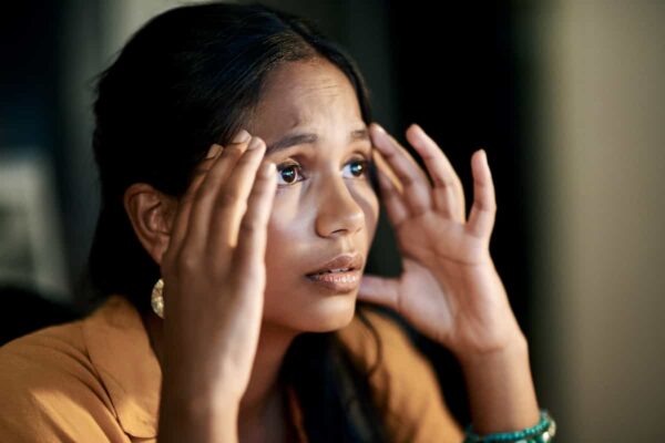Mujer tocándose cuidadosamente el área alrededor de los ojos