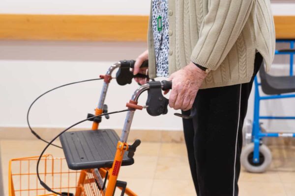 Mujer adulta mayor caminando con ayuda de un andador